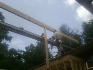 Carpenter setting a ridge beam over a new addition frame — Ice Dam Removal by Roofing Brothers in Mascoutah