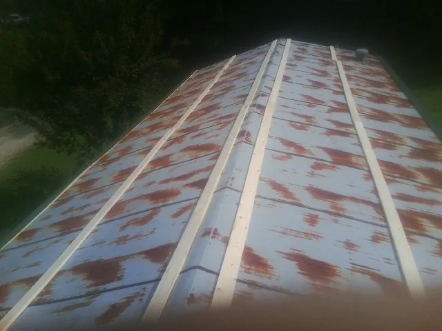 Rusted metal roof panels with new wood purlins before replacement — Storm Damage Roof Repair in Mascoutah by Roofing Brothers